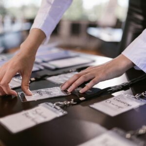 Close-up of hands arranging name tags on a conference table, preparing for a corporate event.