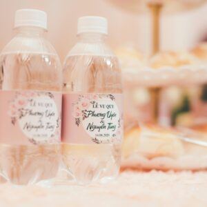 Close-up of personalized wedding water bottles with floral labels.